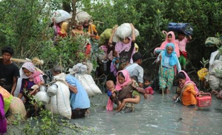 Rohingya Muslims walk through water after crossing the Myanmar border and Naff river to enter Bangladesh. © Getty Images