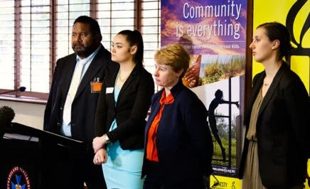 Randall Ross, Justice King, Claire Mallinson and Roxanne Moore stand behind a lectern at the press conference.